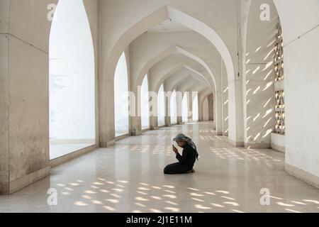 Dhaka, Dhaka, Bangladesh. 25th Mar 2022. Un bambino prega alla Moschea Nazionale di Baiitul Mukarram a Dhaka, Bangladesh. La Moschea Nazionale del Bangladesh, conosciuta come Baitul Mukarram o la Casa Santa in inglese, è una delle 10 moschee più grandi del mondo e può ospitare fino a 40.000 persone, anche nello spazio aperto esterno. La moschea ha diverse caratteristiche architettoniche moderne e allo stesso tempo conserva i principi tradizionali dell'architettura Mughal, che da qualche tempo è stata dominante nel subcontinente indiano. (Credit Image: © Joy Saha/ZUMA Press Wire) Credit: ZUMA Press, Inc./ Foto Stock