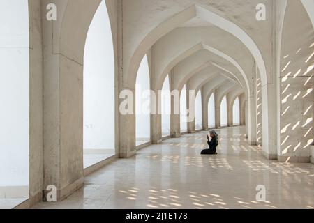 Dhaka, Dhaka, Bangladesh. 25th Mar 2022. Un bambino prega alla Moschea Nazionale di Baiitul Mukarram a Dhaka, Bangladesh. La Moschea Nazionale del Bangladesh, conosciuta come Baitul Mukarram o la Casa Santa in inglese, è una delle 10 moschee più grandi del mondo e può ospitare fino a 40.000 persone, anche nello spazio aperto esterno. La moschea ha diverse caratteristiche architettoniche moderne e allo stesso tempo conserva i principi tradizionali dell'architettura Mughal, che da qualche tempo è stata dominante nel subcontinente indiano. (Credit Image: © Joy Saha/ZUMA Press Wire) Credit: ZUMA Press, Inc./ Foto Stock