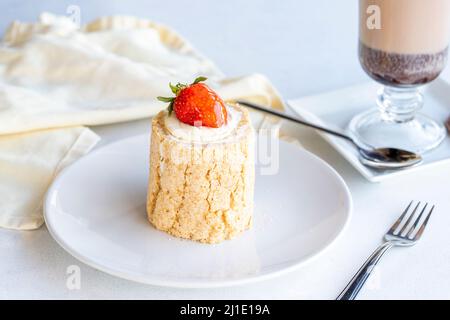 Torta di tronchi di fragola su sfondo bianco. Con cioccolata calda sul lato. Primo piano Foto Stock