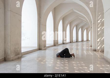 Dhaka, Dhaka, Bangladesh. 25th Mar 2022. Un bambino prega alla Moschea Nazionale di Baiitul Mukarram a Dhaka, Bangladesh. La Moschea Nazionale del Bangladesh, conosciuta come Baitul Mukarram o la Casa Santa in inglese, è una delle 10 moschee più grandi del mondo e può ospitare fino a 40.000 persone, anche nello spazio aperto esterno. La moschea ha diverse caratteristiche architettoniche moderne e allo stesso tempo conserva i principi tradizionali dell'architettura Mughal, che da qualche tempo è stata dominante nel subcontinente indiano. (Credit Image: © Joy Saha/ZUMA Press Wire) Credit: ZUMA Press, Inc./ Foto Stock