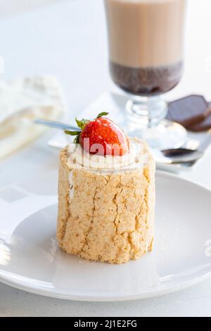 Torta di tronchi di fragola su sfondo bianco. Con cioccolata calda sul lato. Primo piano Foto Stock