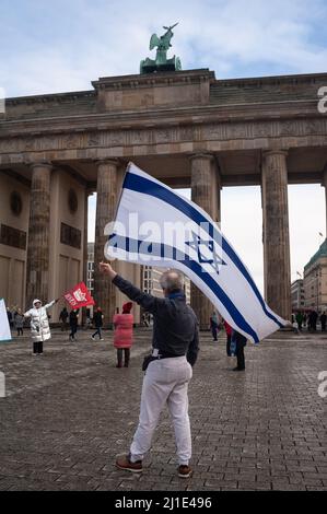 22.01.2022, Germania, , Berlino - Un uomo ondeggia una bandiera israeliana con la Stella di David durante un tranquillo raduno sulla Platz des 18 Maerz di fronte alla B. Foto Stock