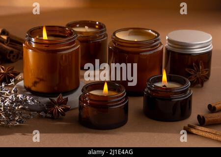 Un set di candele aromatiche diverse in vasetti di vetro marrone