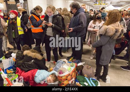 09.03.2022, Germania, Berlino, Berlino - i rifugiati ucraini che arrivano in treno sono curati da volontari alla stazione ferroviaria principale. Un bambino dorme w Foto Stock
