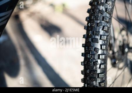 Pneumatico di gomma nera su una ruota anteriore della mountain bike 29 pollici con manopole grandi da vicino ancora Foto Stock