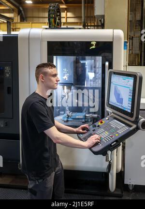 08.03.2022, Germania, Renania settentrionale-Vestfalia, Oberhausen - apprendisti nelle professioni della lavorazione del metallo. Macchinista tirocinante presso una macchina utensile CNC NELL'UOMO Foto Stock