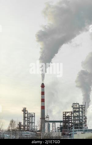 Il lavoro di un impianto petrolchimico. Il fumo proviene dal camino. Foto Stock