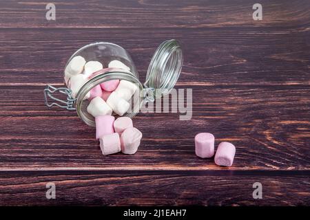 Marshmallows in un vaso di vetro su sfondo di legno Foto Stock
