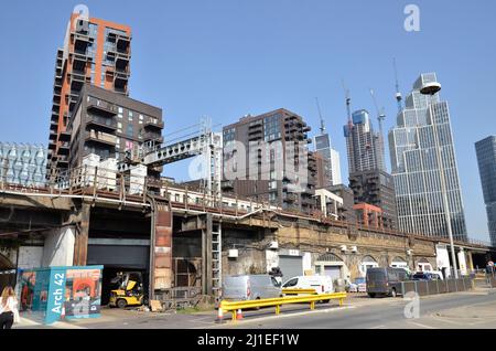 Parte del nuovo sviluppo dei nove Elms nel sud di Londra con nuovi edifici e vecchi archi ferroviari giustapposti Foto Stock