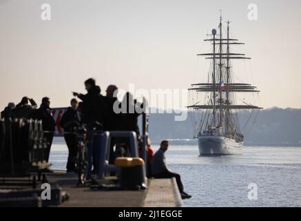 Kiel, Germania. 25th Mar 2022. Parenti e amici salutano il 'Gorch Fock' mentre attracca al molo presso la base navale di Kiel-Wik. La nave da addestramento della marina tornò al suo porto di origine dopo un viaggio di quattro mesi di addestramento e ormeggia al molo di Gorch Fock. Credit: Christian Charisius/dpa/Alamy Live News Foto Stock