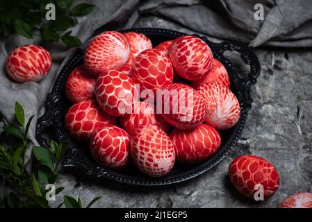 Pizzo dipinto rosso uova di Pasqua in una ciotola con spazio copia vista dall'alto. Sfondo di Pasqua con uova colorate per la tradizione religiosa Foto Stock