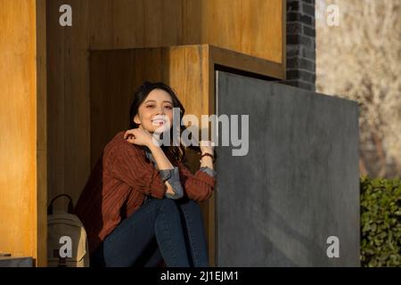 Ragazza giovane seduta fuori una libreria moderna - foto di scorta Foto Stock