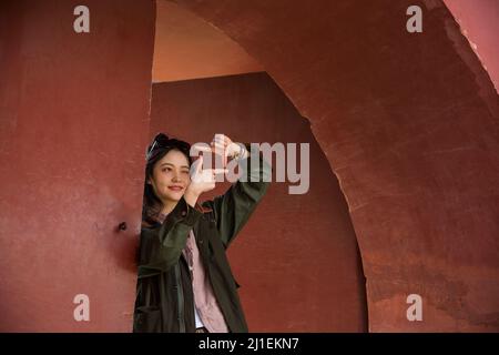 Giovane turista femmina sotto l'arco rosso - foto di scorta Foto Stock