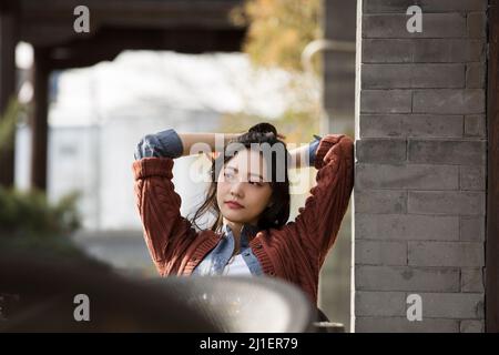 Bella giovane donna cinese che si gode il tè del pomeriggio in caffè marciapiede - foto di scorta Foto Stock