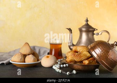 Gustosi dolci orientali e tè con tasbih sul tavolo Foto Stock