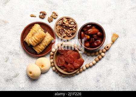 Gustosi dolci orientali con tasbih su sfondo grunge Foto Stock