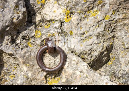 Anello di ferro vecchio in un antico castello muro per fissare qualcosa a. Foto Stock