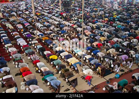 Decine di migliaia di devoti musulmani offrono la preghiera di Jummah alla Moschea Nazionale di Baiul Mukarram a Dhaka, Bangladesh. Circa 10.000-15.000 persone hanno frequentato la Moschea per le loro preghiere settimanali. La Moschea Nazionale del Bangladesh, conosciuta come Baitul Mukarram o la Casa Santa in inglese, è una delle 10 moschee più grandi del mondo e può ospitare fino a 40.000 persone, anche nello spazio aperto esterno. La moschea ha diverse caratteristiche architettoniche moderne e allo stesso tempo conserva i principi tradizionali dell'architettura Mughal, che da qualche tempo è stata dominante nel subcontinente indiano Foto Stock