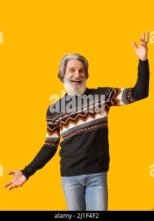 Bell'uomo anziano felice in maglia su sfondo giallo Foto Stock