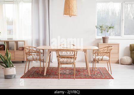 Interno di sala da pranzo luminosa con tavolo e tappeto vintage Foto Stock