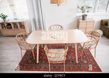 Interno di sala da pranzo luminosa con tavolo e tappeto vintage Foto Stock