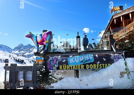 Modello di vacca multicolore contro un cielo blu brillante: Il logo del ristorante Kuhtaier Dorfstadl nello sci della località di Kuhtai, Alpi tirolesi, Austria Foto Stock