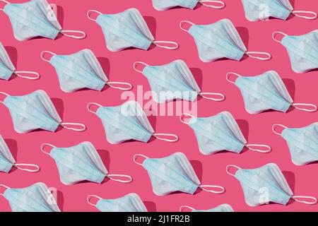 Maschera respiratoria o chirurgica. Protezione da coronavirus o COVID-19 su rosa trendy. Concetto di modello pandemico o epidemico. Foto Stock