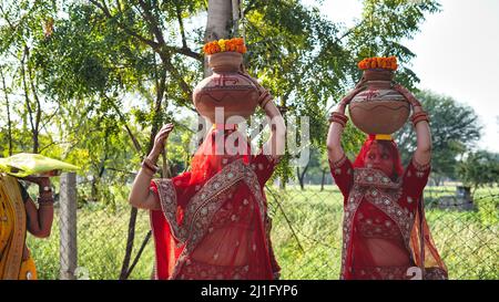 23 marzo 2022 Reengus, Rajasthan, India. Le donne indiane tradizionali che tengono il Kalash di Clay sulla testa su un festival indù. Concetto di religione indù. Foto Stock