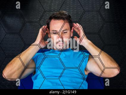 Forme esagonali modello contro caucasico fit uomo che esegue crunches esercizio in palestra Foto Stock