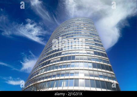 Düsseldorf (Bennigsen-Platz), Germania - Marzo 21. 2022: Vista ad angolo basso sulla torre dello skyoffice contro il cielo azzurro spettacolare con le nuvole soffici Foto Stock