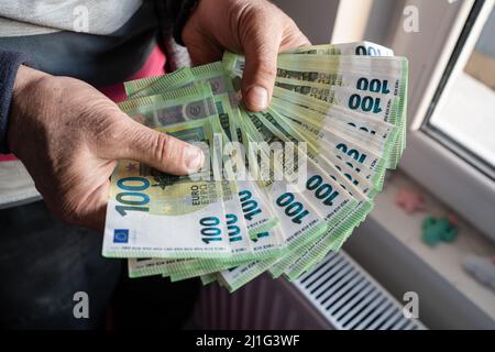 Primo piano sulle mani di un anziano caucasico sconosciuto che detiene e conta 100 banconote in euro pagamento di assicurazione patrimoniale denaro o copia di risparmio a vita spac Foto Stock