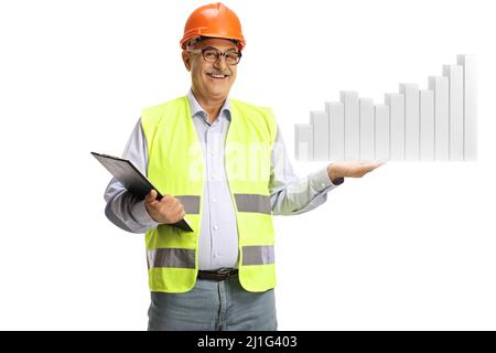 Ingegnere maschio maturo con un gilet di sicurezza che tiene un diagramma a barre isolato su sfondo bianco Foto Stock