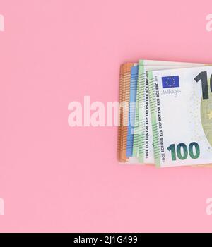 Confezione di banconote in euro su sfondo rosa. Valuta europea, affari, finanza Foto Stock