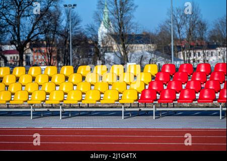 un frammento della tribuna di uno stadio sportivo con sedili multicolore Foto Stock