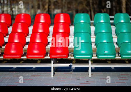 un frammento della tribuna di uno stadio sportivo con sedili multicolore Foto Stock