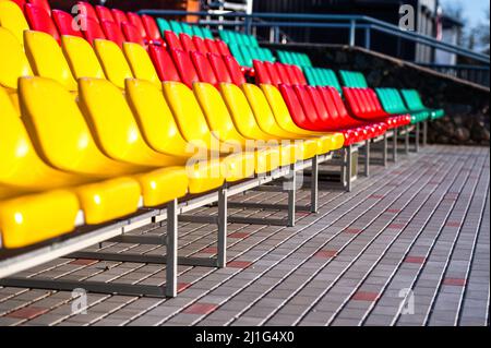 un frammento della tribuna di uno stadio sportivo con sedili multicolore Foto Stock