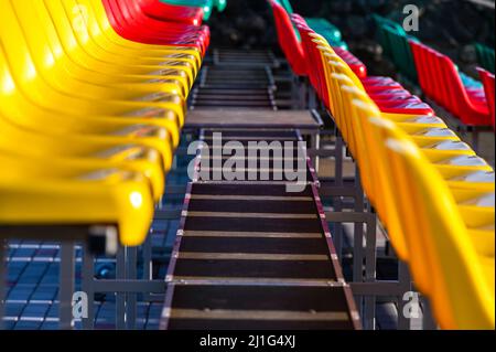 un frammento della tribuna di uno stadio sportivo con sedili multicolore Foto Stock