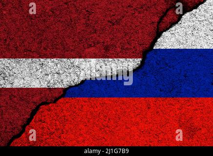 Bandiere di Lettonia e Russia dipinte su pareti di cemento fessurate Foto Stock
