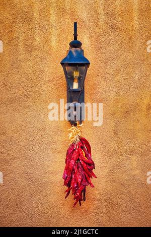 Un mazzo di peperoncini secchi appesi a una lampada. Foto Stock