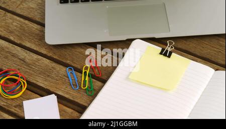 Immagine del testo "Keep your desk clean" sulla nota gialla della memoria sulla scrivania con computer portatile, caffè e notebook Foto Stock