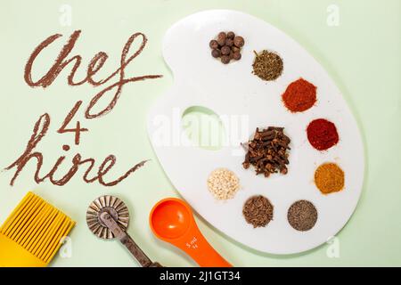 Chef 4 noleggio scritto su carta accanto alla tavolozza di un pittore con spezie secche, e utensili da cucina Foto Stock