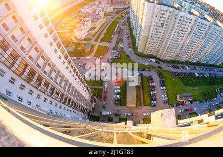 Vista dall'alto del balcone al tramonto e sul cortile del paesaggio cittadino con auto e parcheggio Foto Stock
