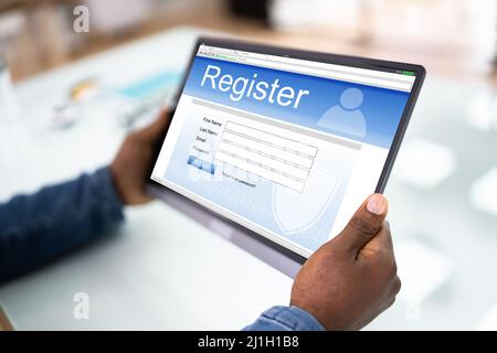 Businessman's Hand Filing modulo di registrazione online su Tablet Foto Stock