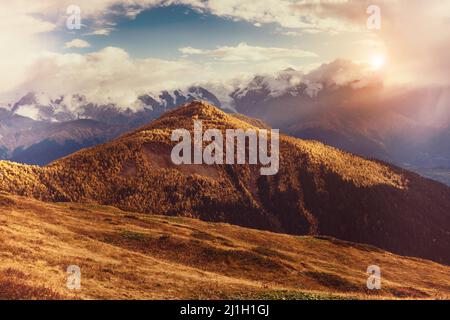 Bella vista sui piedi del Monte Ushba illuminato dalla luce del sole. Scena mattutina suggestiva e pittoresca. Località famosa Place Mestia, Upper Svaneti, Geor Foto Stock