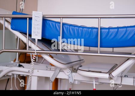 Telecomando e materasso blu di un letto d'ospedale senza persone né lenzuola Foto Stock