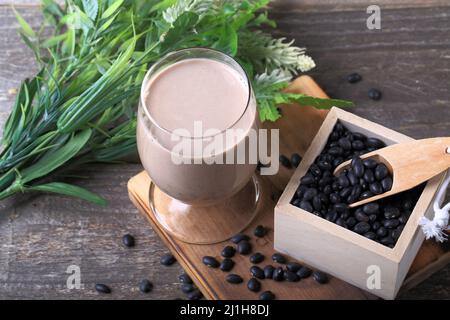 Fagioli neri su tagliere di legno Foto Stock