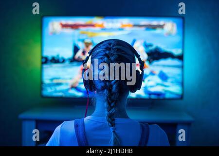 Una ragazza è un giocatore o uno streamer di fronte a una televisione playing.IT è possibile utilizzare come sfondo Foto Stock