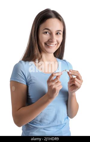 Giovane donna con cerotto applicato di nicotina e sigaretta rotta su sfondo bianco. Cessazione del fumo Foto Stock