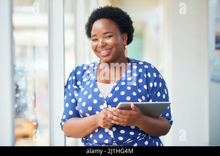 Non dovete smettere di muovervi grazie alla tecnologia mobile. Scatto di una giovane donna d'affari che usa un tablet digitale in un ufficio moderno. Foto Stock