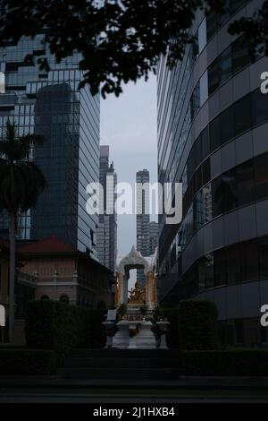 Un piccolo santuario antico tra grattacieli moderni, in un centro di Bangkok Foto Stock